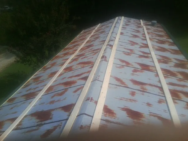 Rusted metal roof panels with new wood purlins before replacement — Storm Damage Roof Repair in Penney Farms by Roofing Brothers